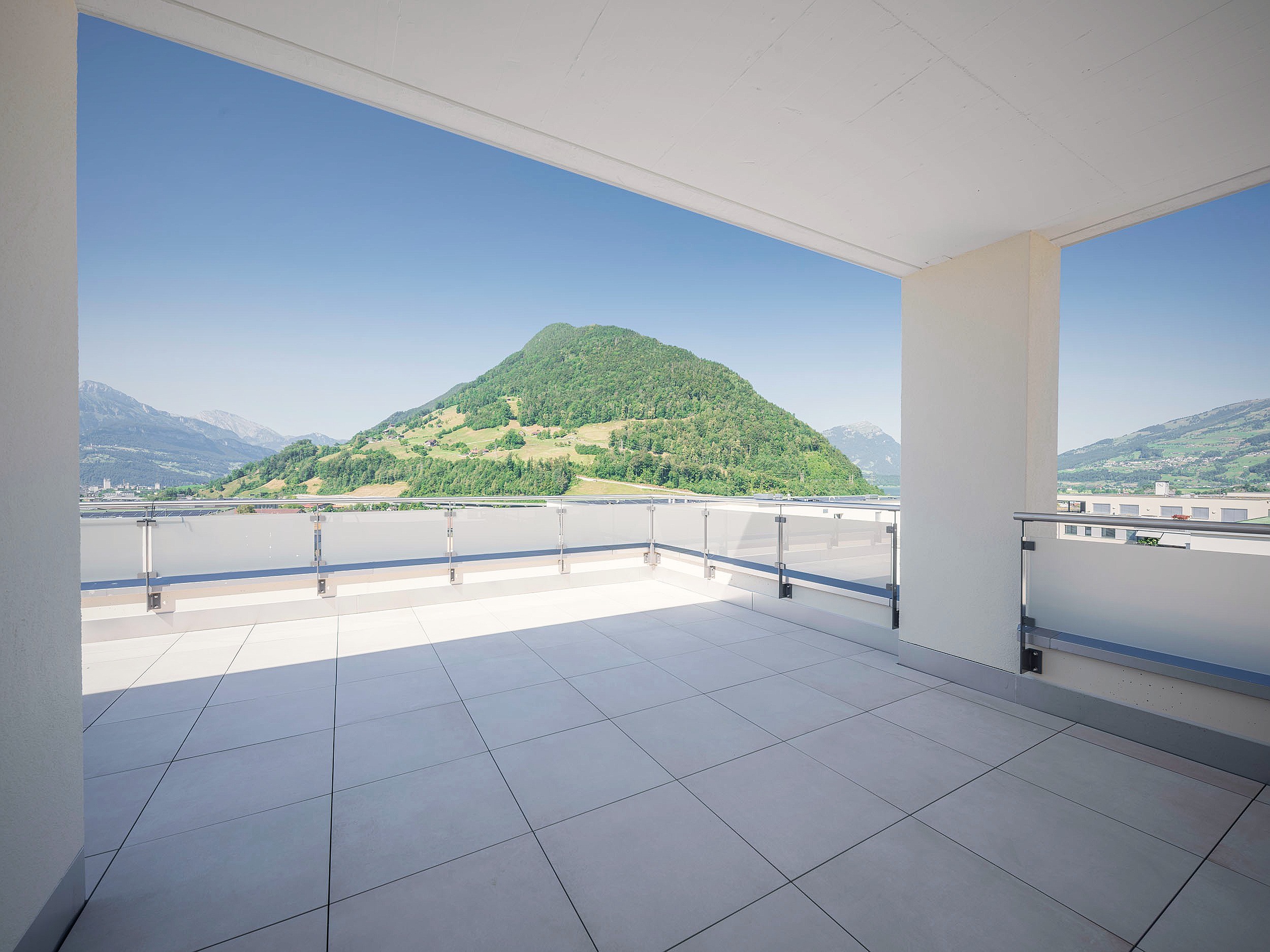 Gedeckte Terrasse mit Blick auf den bewaldeten Berg